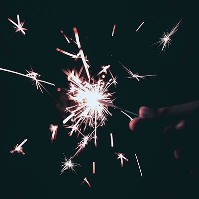 a hand holding a sparkler at night