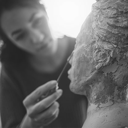 A young woman working on a sculpture